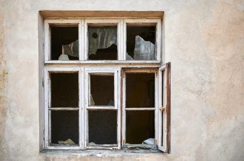 Broken window in old wall of abandoned house Stock Photos