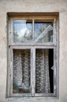 Broken window in old wall of abandoned house Stock Photos