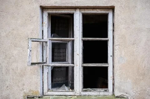 Broken window in old wall of abandoned house Stock Photos
