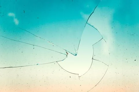 Broken window pane with intricate cracks and shattered glass fragments silh.. Stock Photos