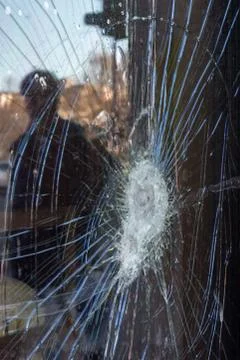 A broken window with a reflection of a person Foto stock