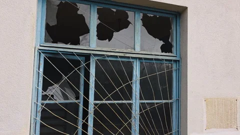 Broken window with shattered glass panes in an abandoned house, a symbol of 스톡 동영상 329746439