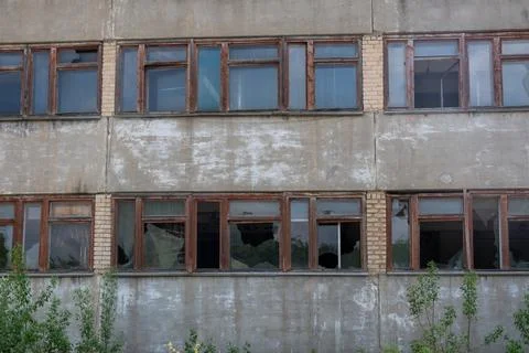 Broken windows in the facade of an old building after an accident, earthqua.. Stock Photos