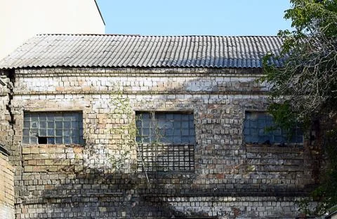 Broken windows in an old building on the grounds of an abandoned factory Stock Photos