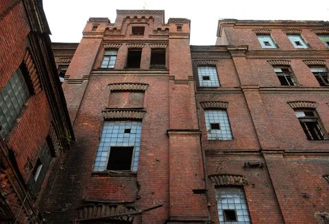 Broken windows in an old building on the grounds of an abandoned factory. Stock Photos
