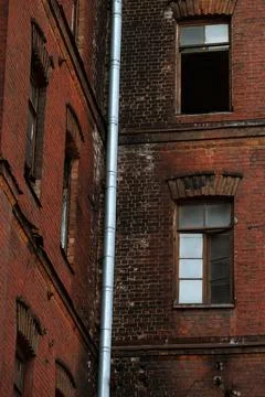 Broken windows in an old building on the grounds of an abandoned factory. Stock Photos