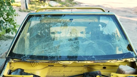 Broken windshield on abandoned yellow car showing severe damage from an accident Stock Footage 340509364