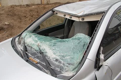 Broken windshield. A broken silver car after an accident on the road. Transport Stock Photos