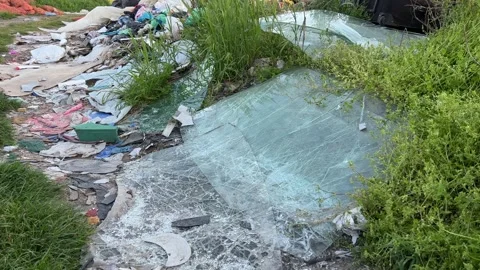 Broken windshield of a car in a garbage dump Stock Footage 240242439