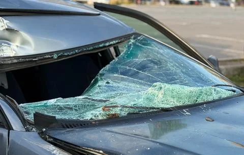 A broken windshield of a car as a result of a traffic accident. Stock Photos