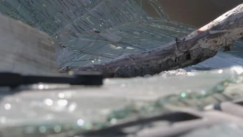 Broken windshield of a car. Window broken due to vandalism. Camera turning left. Stock Footage 276627915
