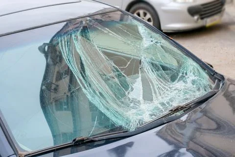 Broken windshield of damaged car after accident in city street Stock Photos