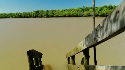 Broken wooded dock overlooking a huge river Stock Footage 163984189