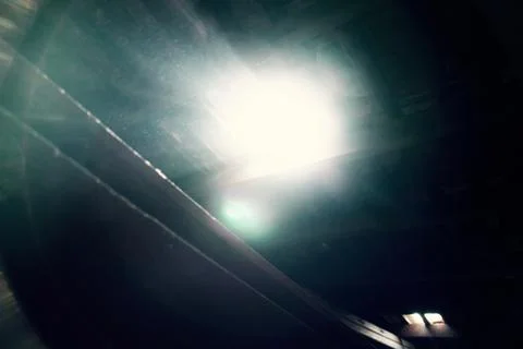 Broken wooden ceiling casting sunlight through a hole. Stock-Fotos