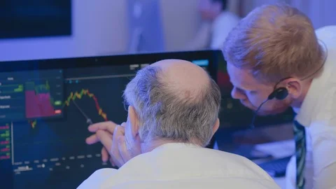 Brokers looking at screen and discuss graphics Stock Footage 116101902