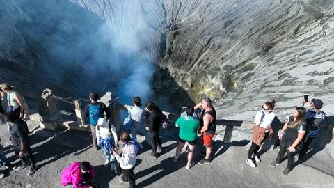 BROMO, JAVA, INDONESIA, JUNE 12, 2023: Visitors stand on the rim of a dramatic Stock Photos