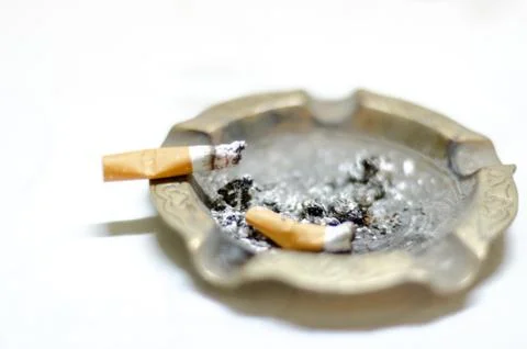 Bronze ashtray with cigarettes with shallow depth of field Foto stock