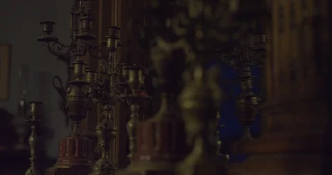 Bronze candlestick collection on a fireplace in front of a mirror in a spooky Vídeos de archivo 110699636