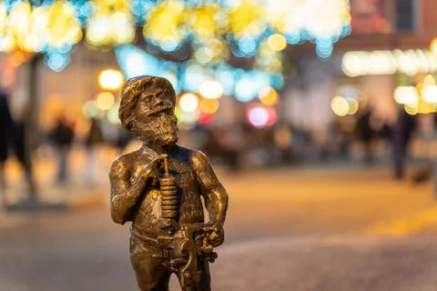 Bronze dwarf statue stands proudly in Market Square, Wroclaw amidst festive Stock Photos