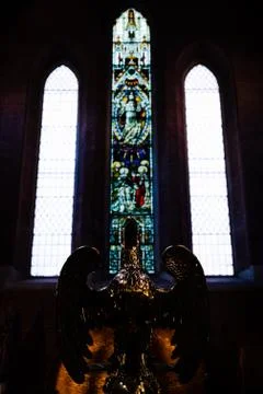 Bronze eagle statue in front of stained glass windows inside a church in Rome Stock Photos