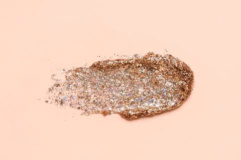 Bronze glitter stroke on beige background Stock Photos