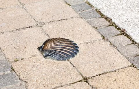 This bronze shell is set into a stone pathway, marking a trail at a significa Stock Photos