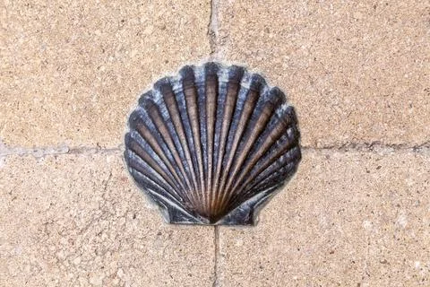 This bronze shell is set into a stone pathway, marking a trail at a significa Stock Photos
