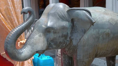 Bronze statue of an elephant with raised trunk in the temple grounds  Stock Footage 308892266