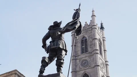 Bronze statue of man facing neo-gothic church tower Stock Footage 255340670