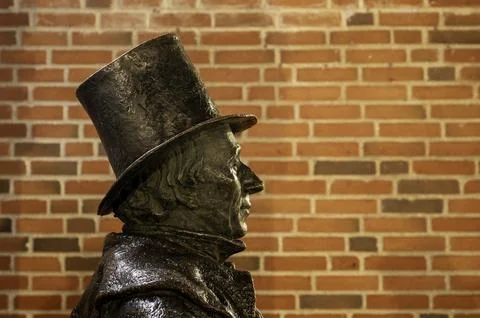 Bronze statue of the writer H. C. Andersen against a brick wall in Odense Stock Photos