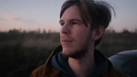 Brooding and mysterious look into the distance the young man looks Stock Footage 131360376