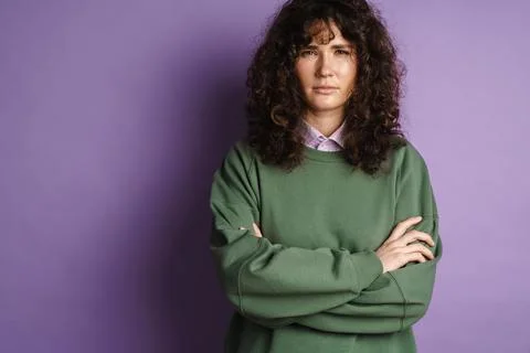 Brooding beautiful curly girl posing with arms crossed Stock Photos