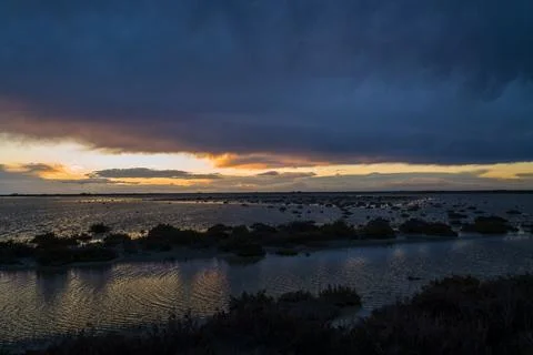 Brooding clouds at sunset over Camargue marsh Stock Photos