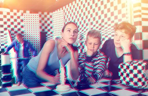 Brooding family trying to find a solution to a puzzle in the quest room Stock Photos
