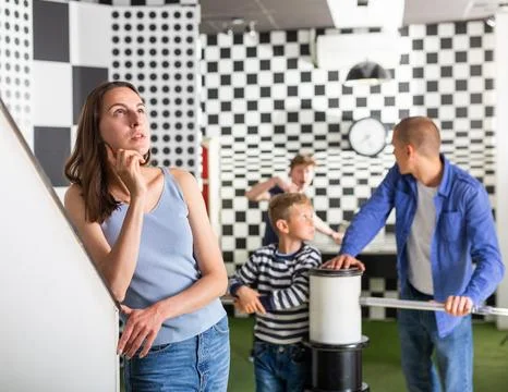 Brooding family trying to find a solution to a puzzle in the quest room Stock Photos