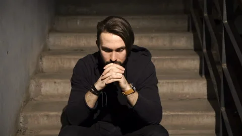 Brooding guy is sitting on the stairs Stock Footage 86259035