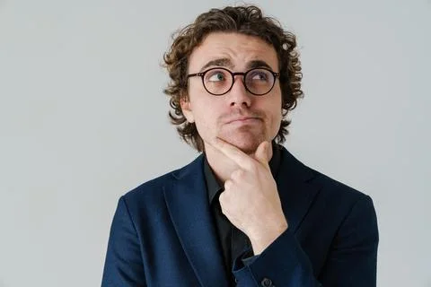 Brooding handsome man in eyeglasses thinking and looking aside Stock Photos