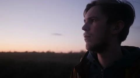 Brooding look into the distance the young man looks in the evening Stock Footage 131360691