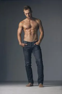 Brooding masuclinity. Studio shot of a shirtless muscular man wearing jeans. Stock Photos