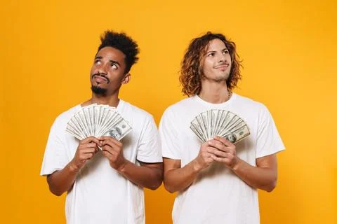 Brooding multicultural two guys posing with dollars Stock Photos