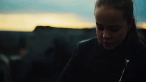 Brooding schoolgirl with ponytail looking down. Portrait of girl in black Video stock 98603217