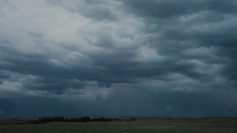 Brooding storm clouds flicker with lightning in night sky Stock Footage 337854521