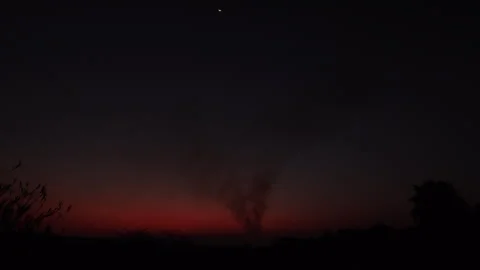 Brooding Wild Fire on outskirts of City with Bats flying through Stock Footage 248774634