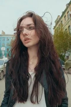 Brooding woman with windy hai posing outside, street fashion Stock Photos