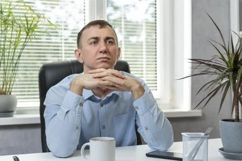 Brooding young man in the office. Portrait of middle-aged director in his own Stock Photos