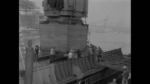BROOKLYN - 1955 - Workers assist the crane in positioning the gigantic gun mount Stock Footage 308101604