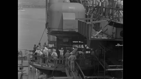 BROOKLYN - 1955 - Workers crowd the deck of the USS Saratoga to guide the crane Video stock 308105240
