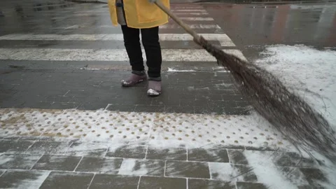 Broom in the hands of a utility worker sweeping the sidewalk.  Stock Footage 266406856