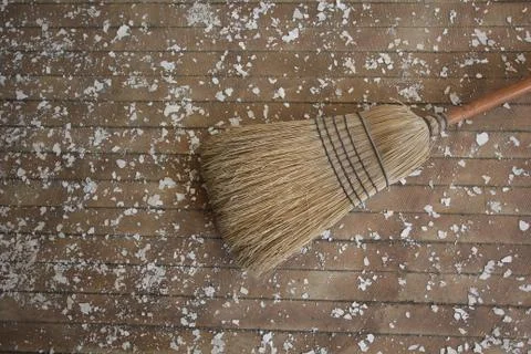 Broom lying down on a floor with paint chips Stock Photos
