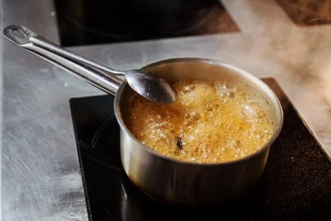 Broth is boiling in the pot on the induction cooker. Stock Photos